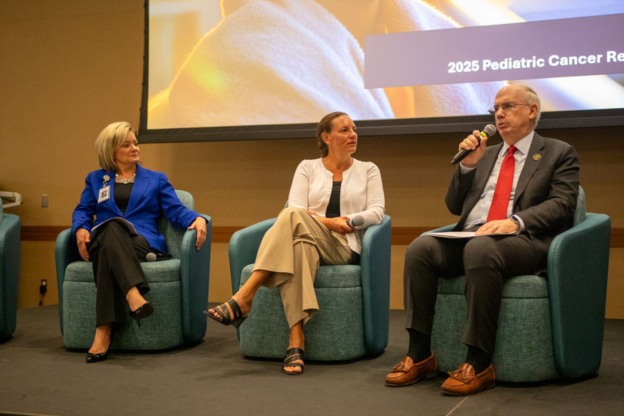 Three people sitting on stage as part of a panel