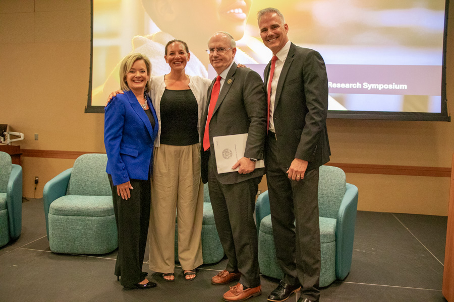 four people posing on a stage at a CHRI event