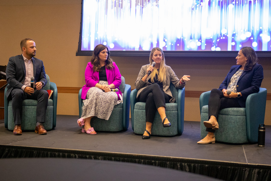 four people sitting on stage talking