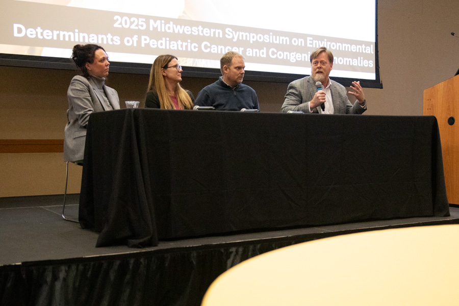 four people sit on stage and take part in panel discussion