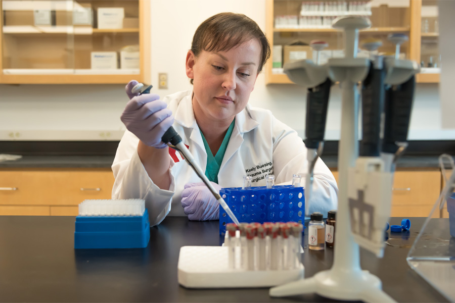 A faculty member works at a microscope