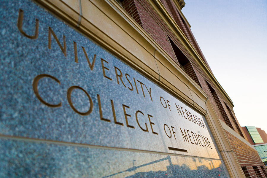 Exterior of the College of Medicine focused on a plaque that reads "University of Nebraska College of Medicine"