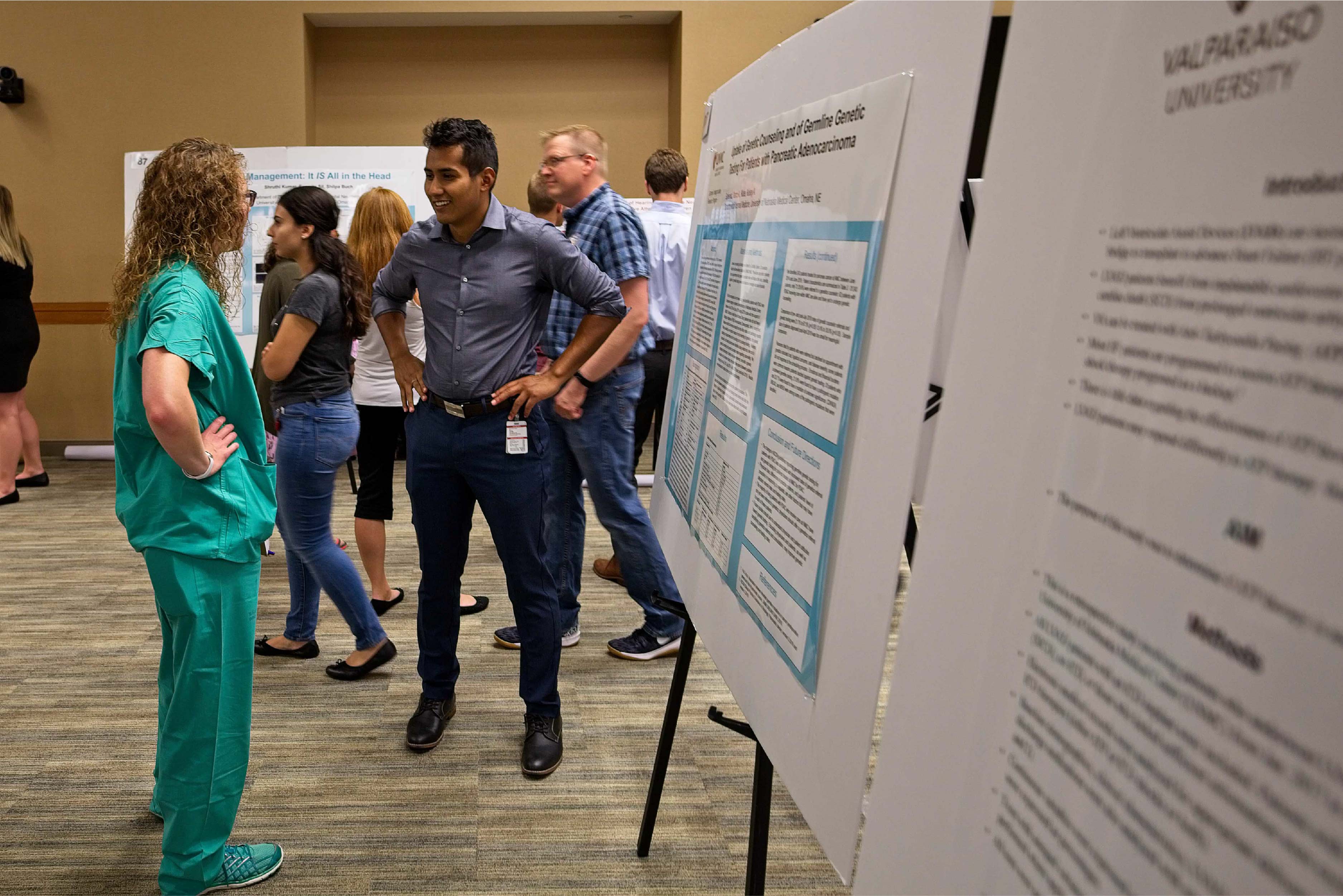 A student presents information on a research poster to observers