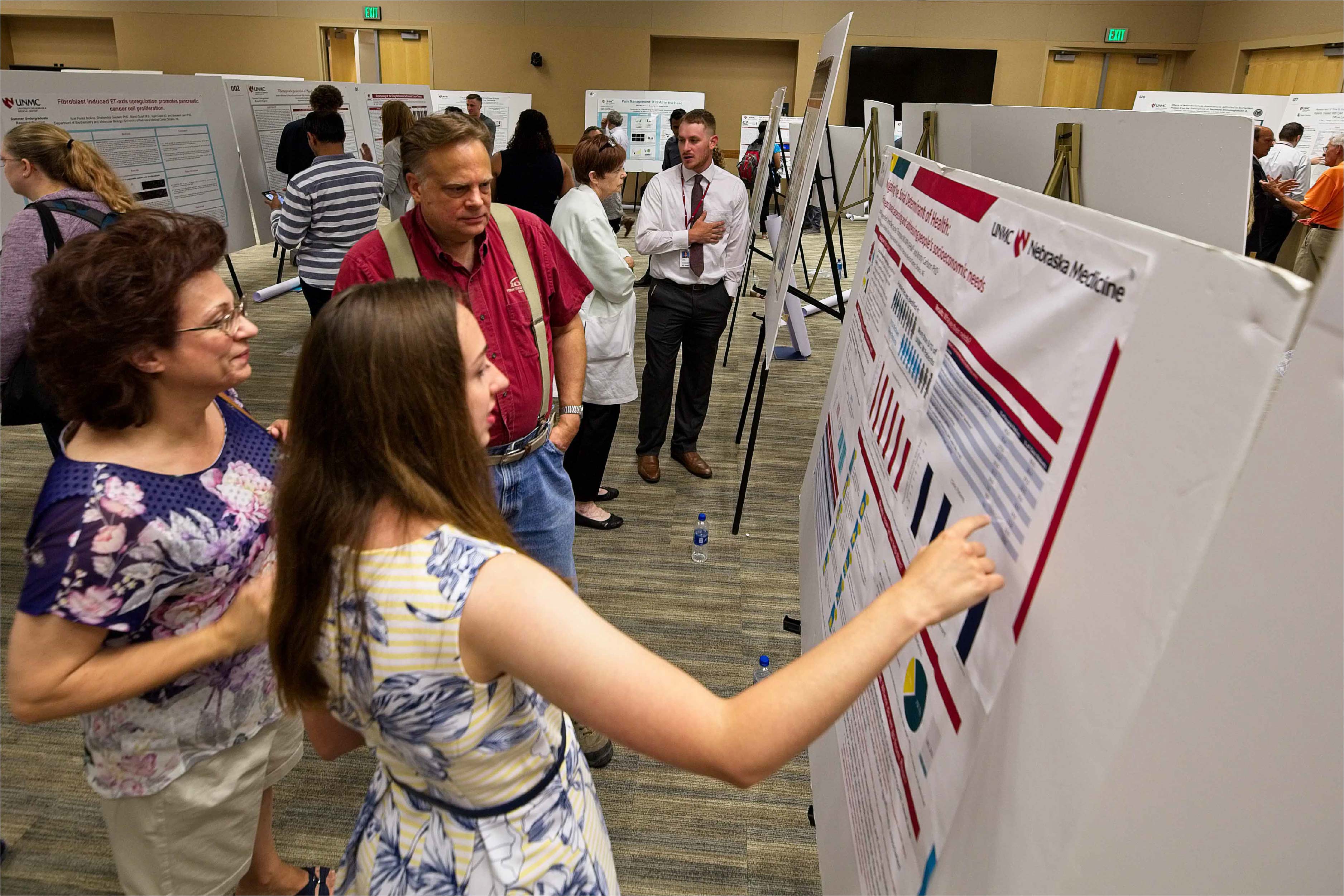 A student presents information on a research poster to observers