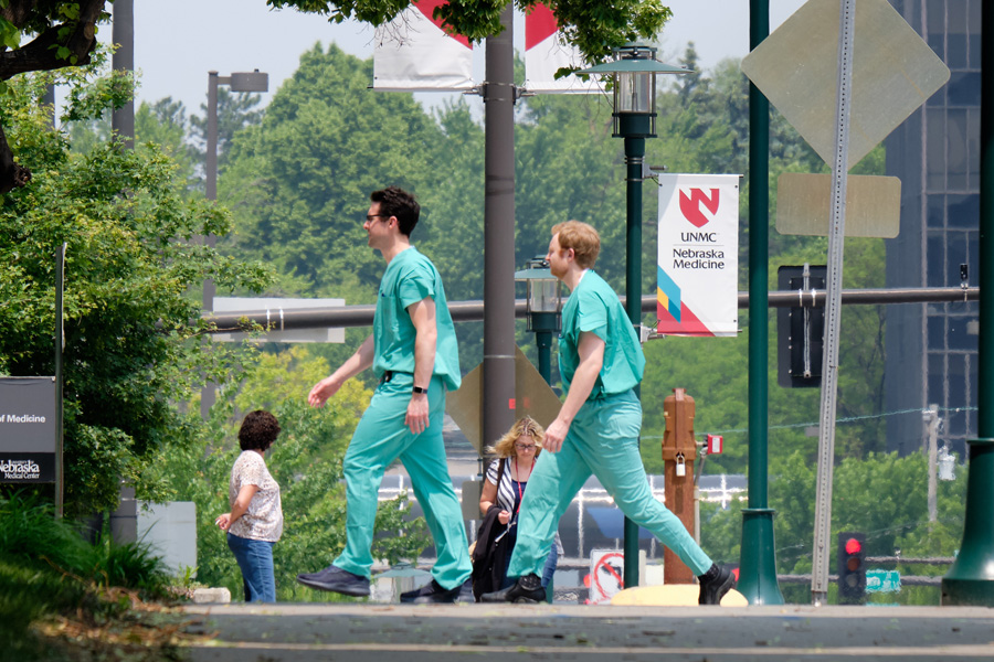 Two students in scrubs walk on campus