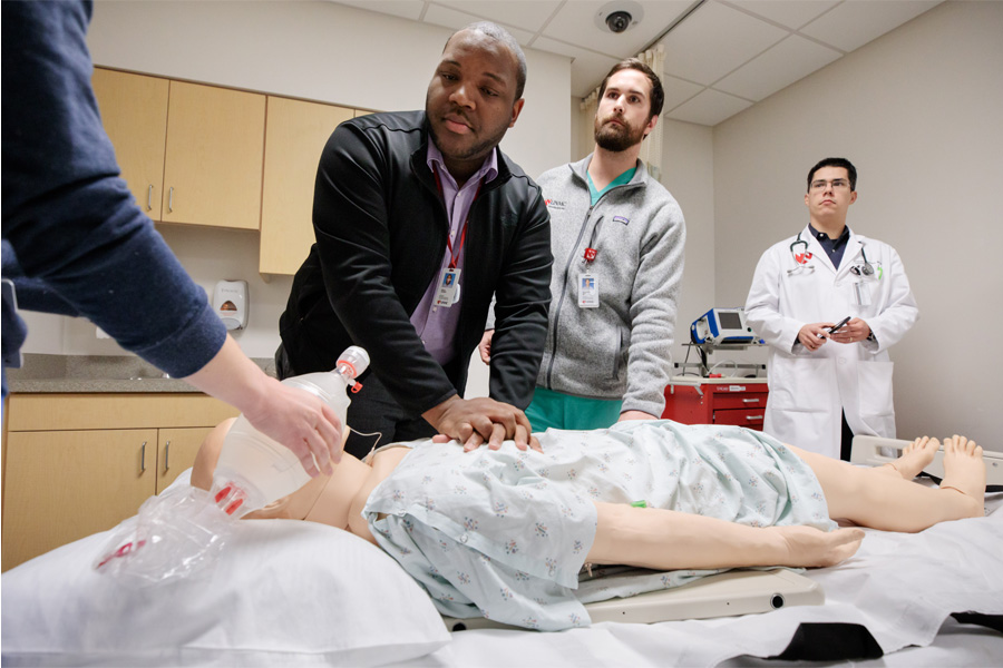 Residents with work a mannequin in a clinical setting