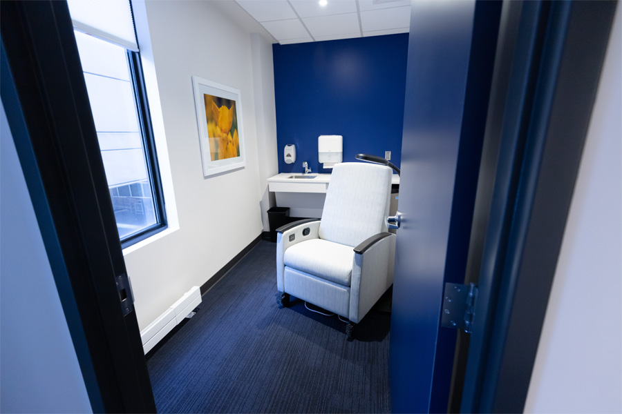 A seating area with a white cushioned chair and a framed picture