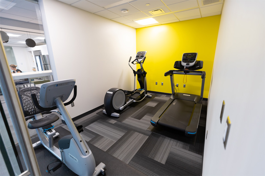 A room with a treadmill, an elliptical, and a bike machine