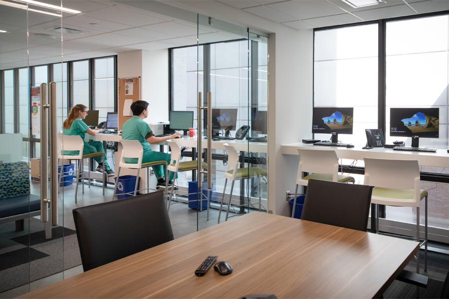 Two students work at computers in a lounge