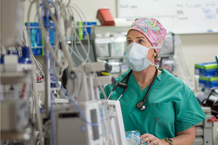 An anesthesiologist works with medical equipment