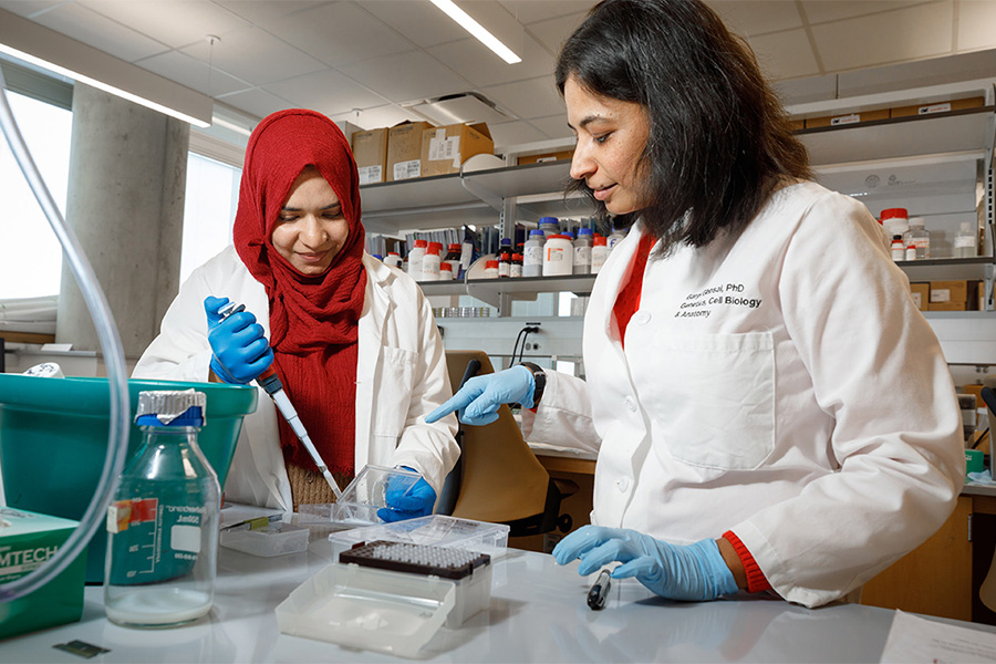 Gargi Ghosal, PhD., works with a student in a lab.