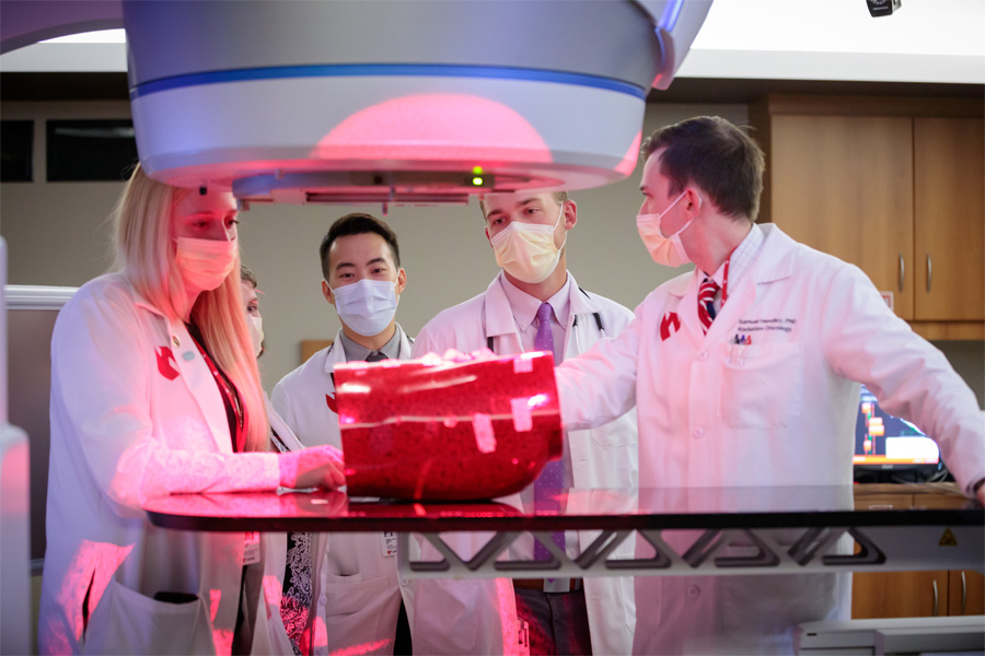 Two health care workers examine scans on a computer