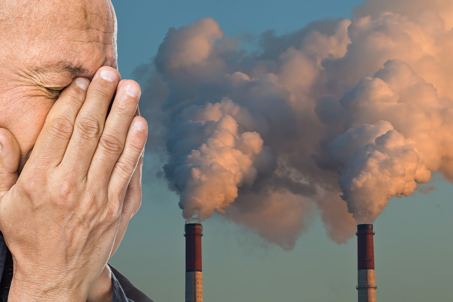 Person coughing with pollution in the background