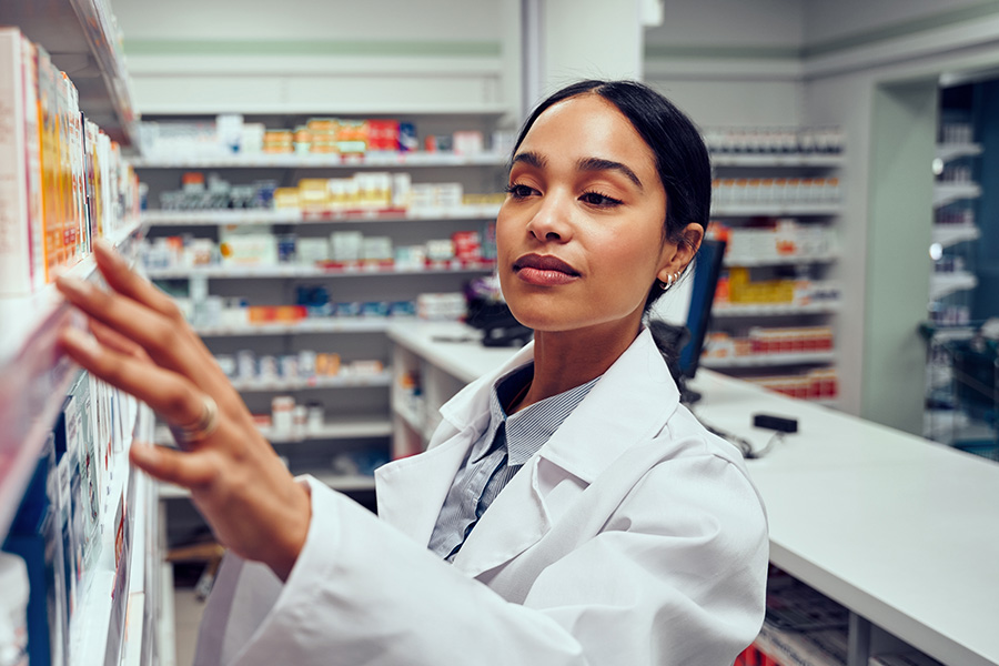 Pharmacist getting medication of a shelf