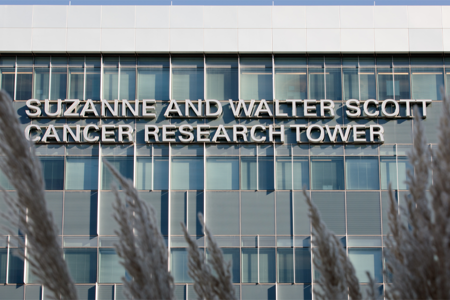 Exterior of a building with a sign reading "Suzanne and Walter Scott Cancer Research Tower"