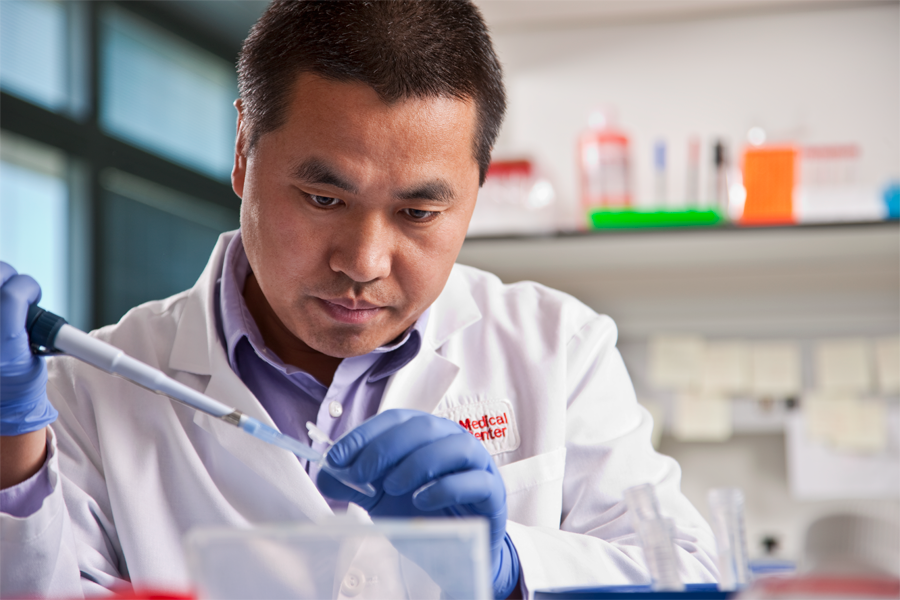 Dr. Jixin Dong uses a pipette in his lab