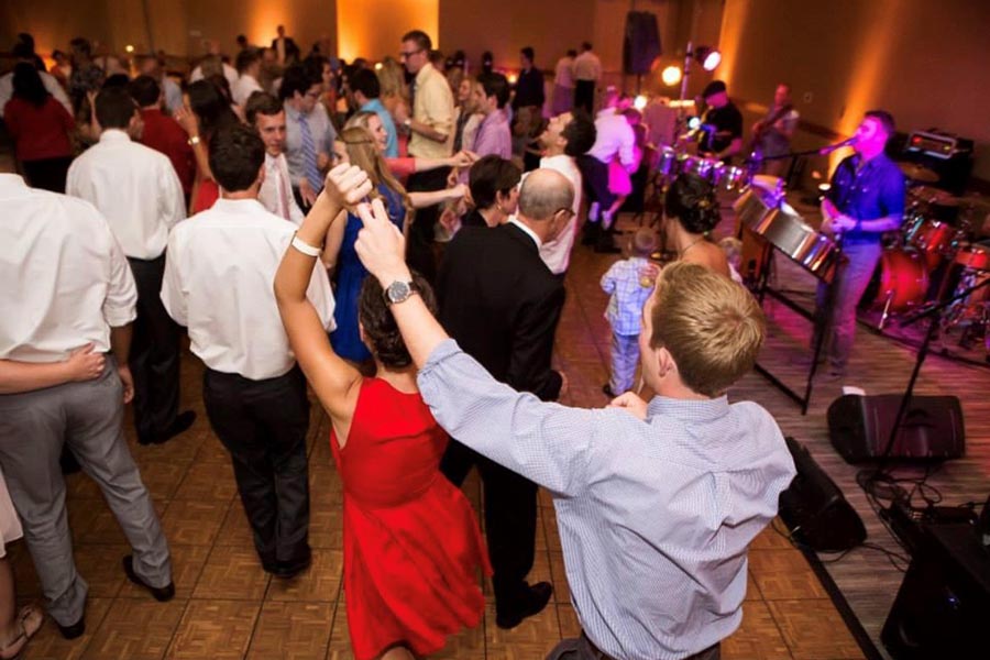 Guests dance to a live band on the dance floor at a wedding reception in the Truhlsen Campus Events Center.