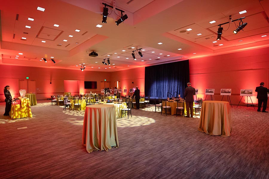 The Events Center is set for a formal dinner with dramatic red uplighting.