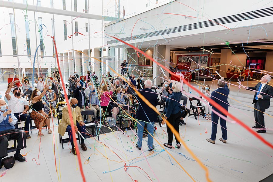 Guests shoot confetti streamers to celebrate the opening of the Wigton Heritage Center in the atrium space.