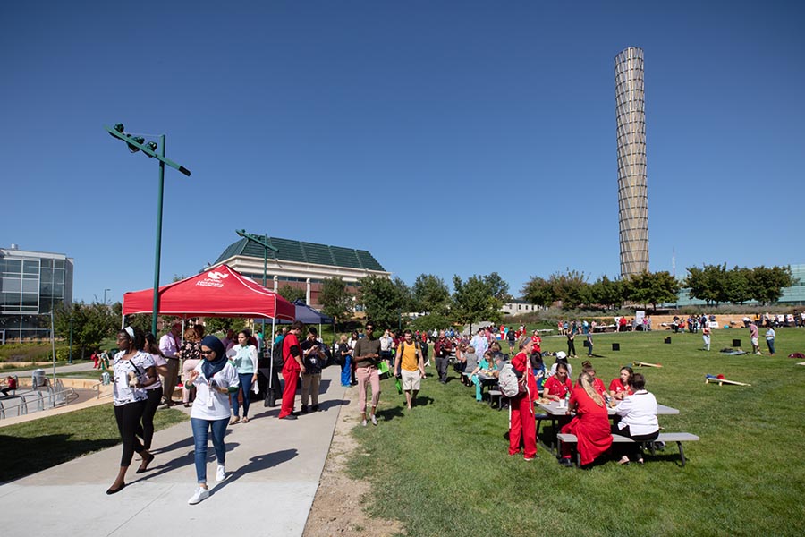 UNMC students and staff gather outdoors at the campus BBQ.