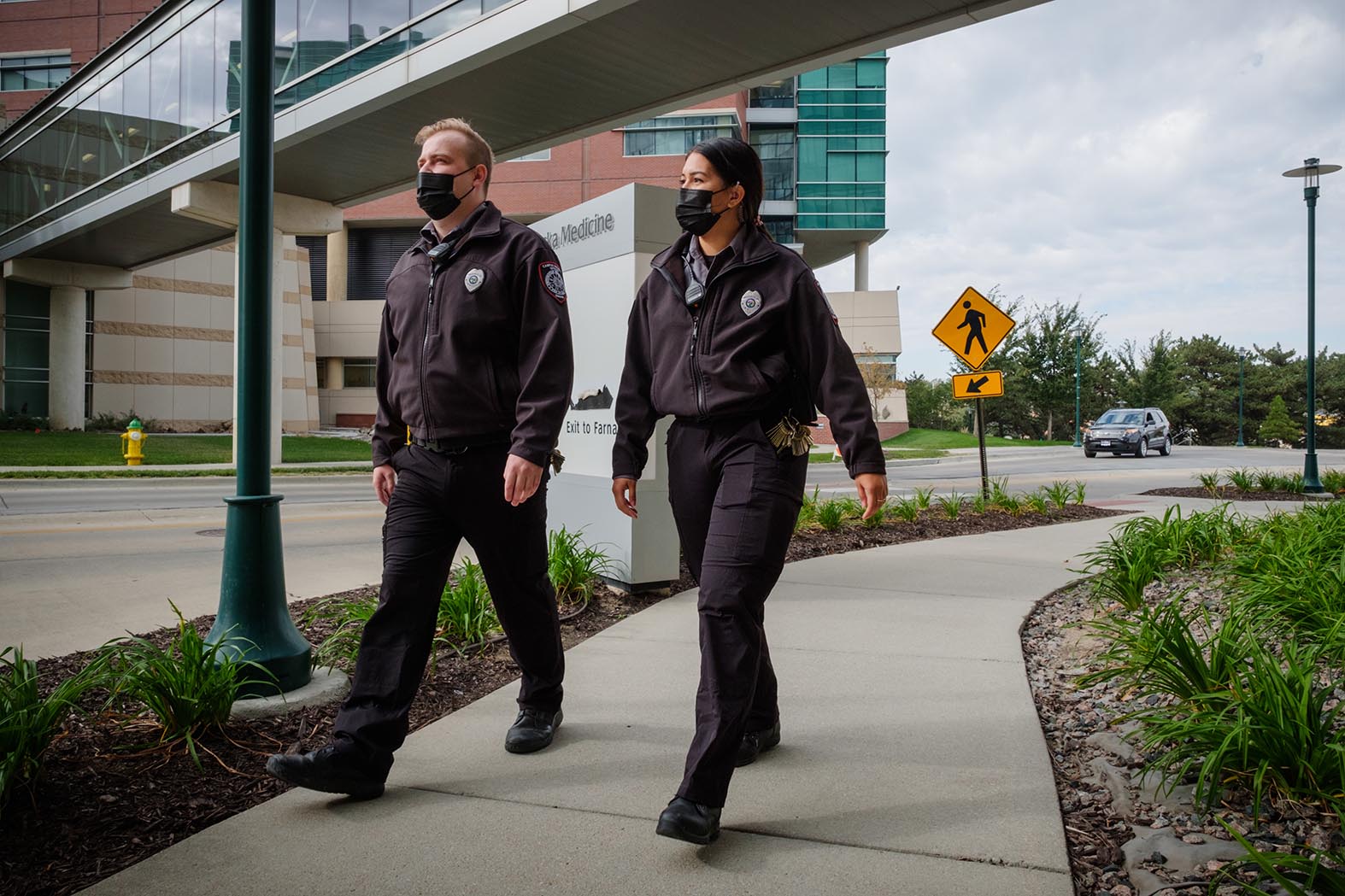 Campus security in uniforms walking outdoors.