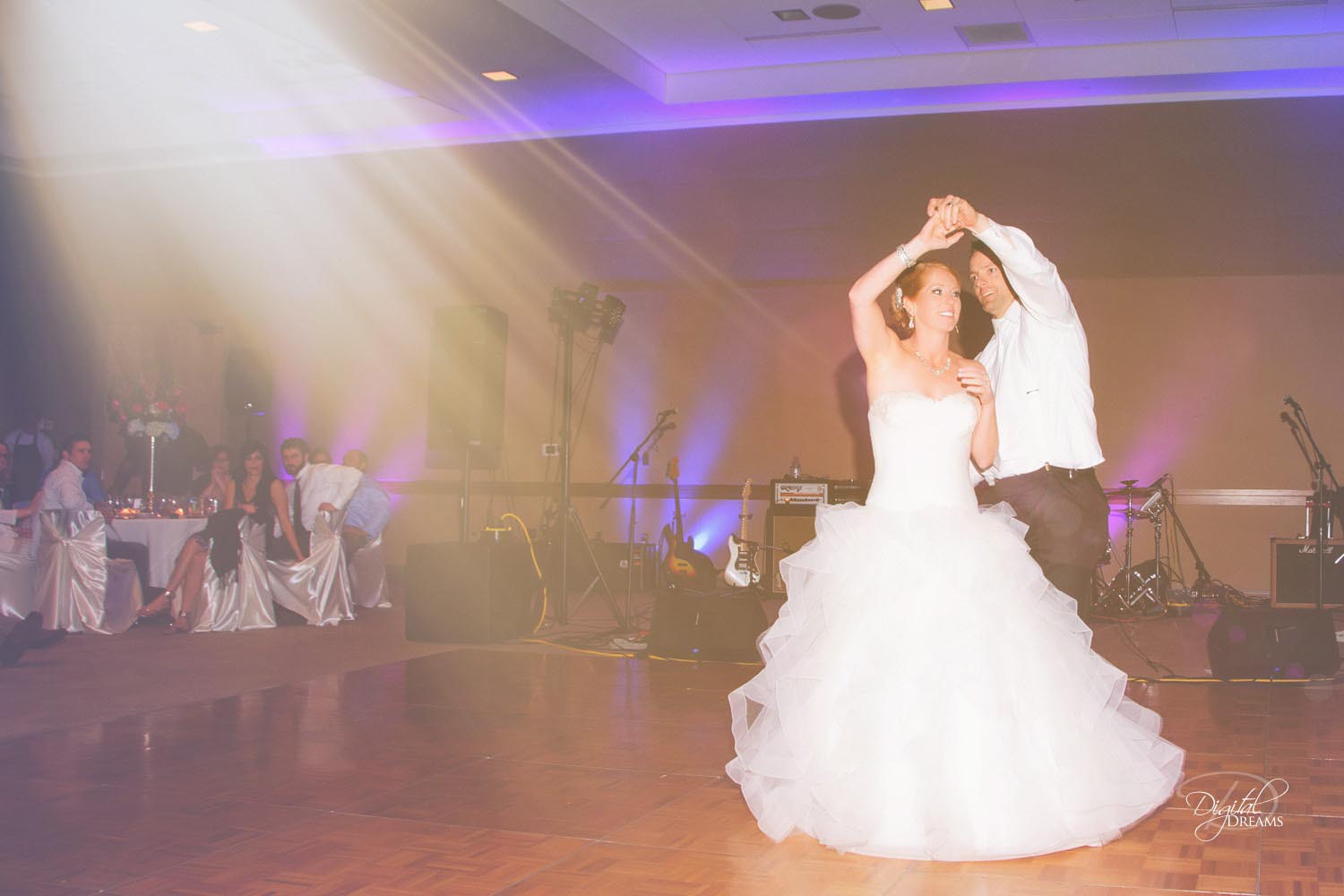 A newly married couple dances their first dance at their reception.