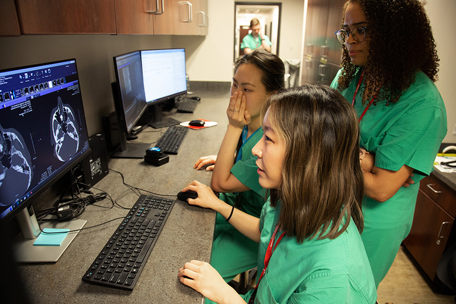 Ophthalmology residents talk over a case in clinic.