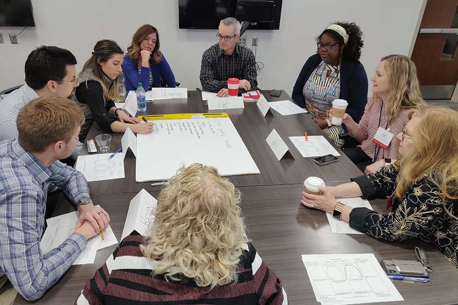 faculty interacting around a table