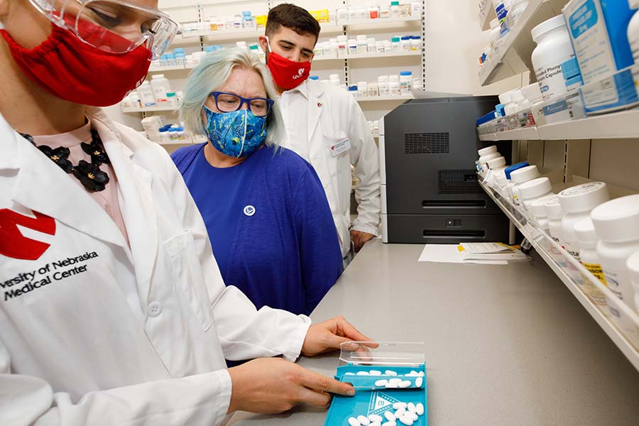 pharmacy faculty member overseeing student counting medication