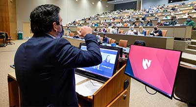 faculty member presenting to students in a large lecture hall