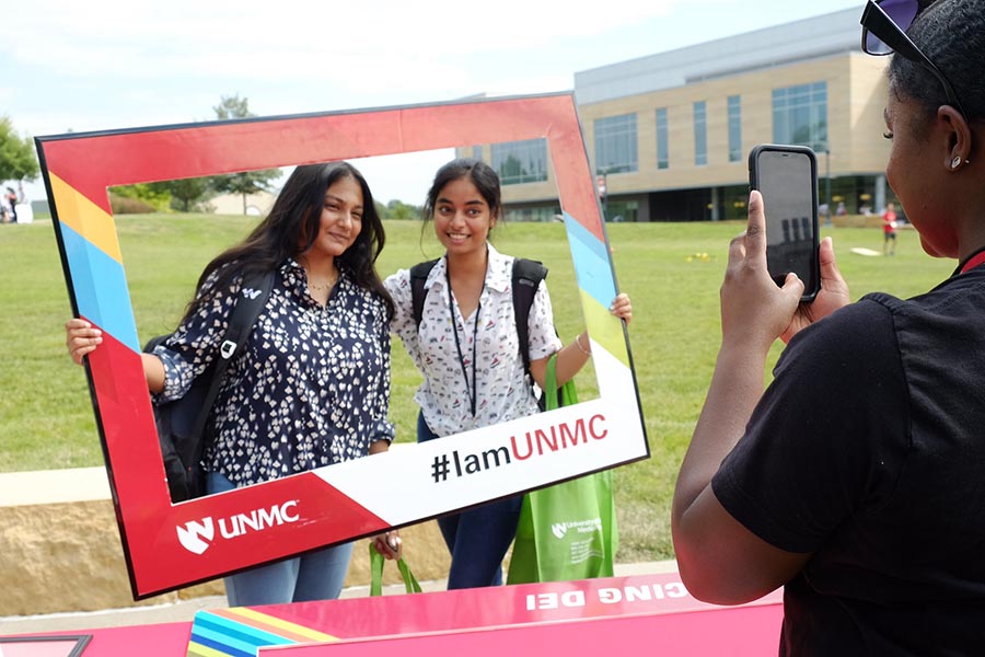 Students pose for a photo with an iamunmc social frame
