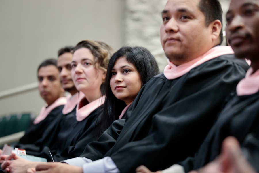 Students wearing academic attire prepare for a graduation ceremony