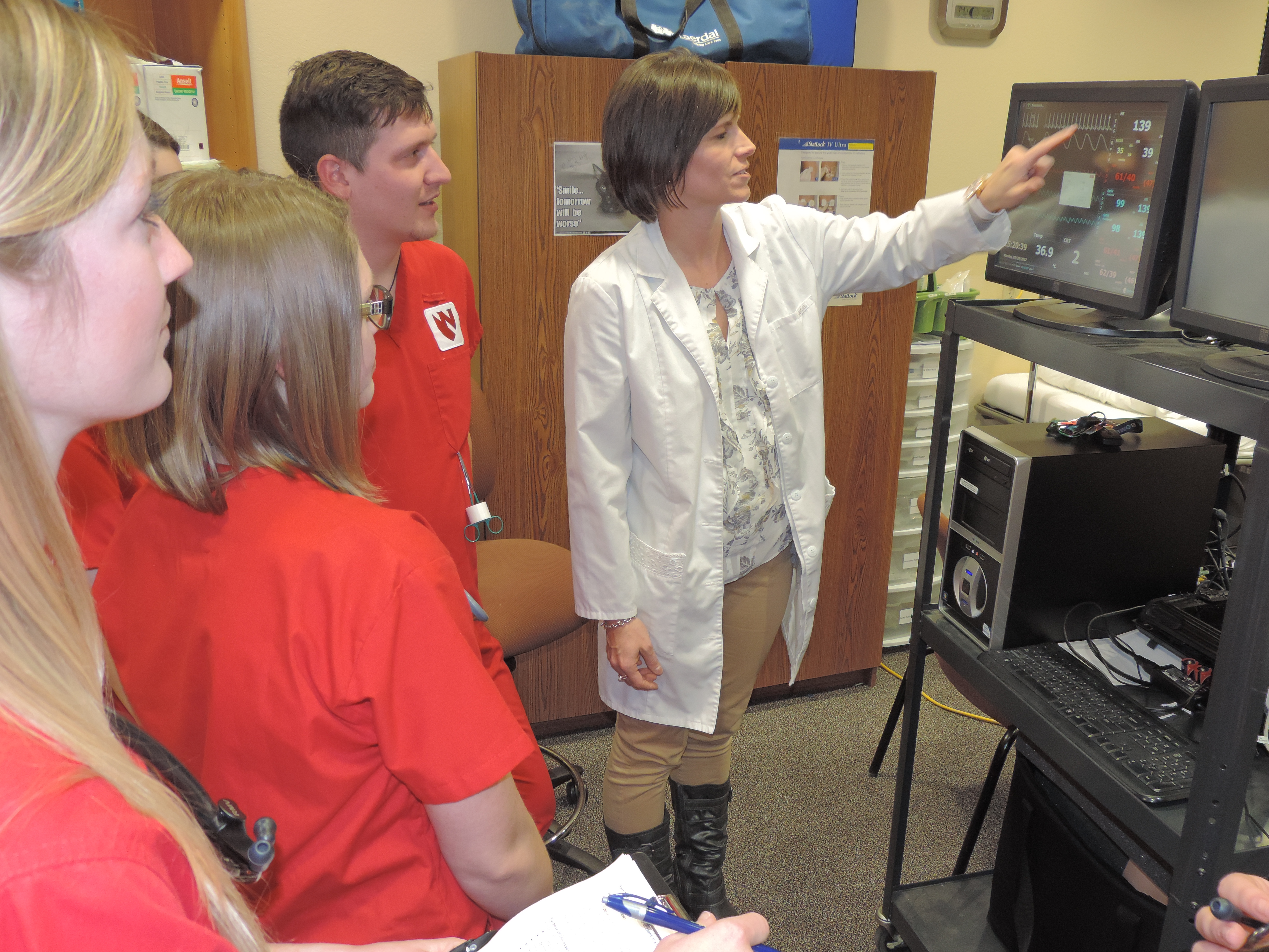 Nursing teacher pointing to screen educating nursing students