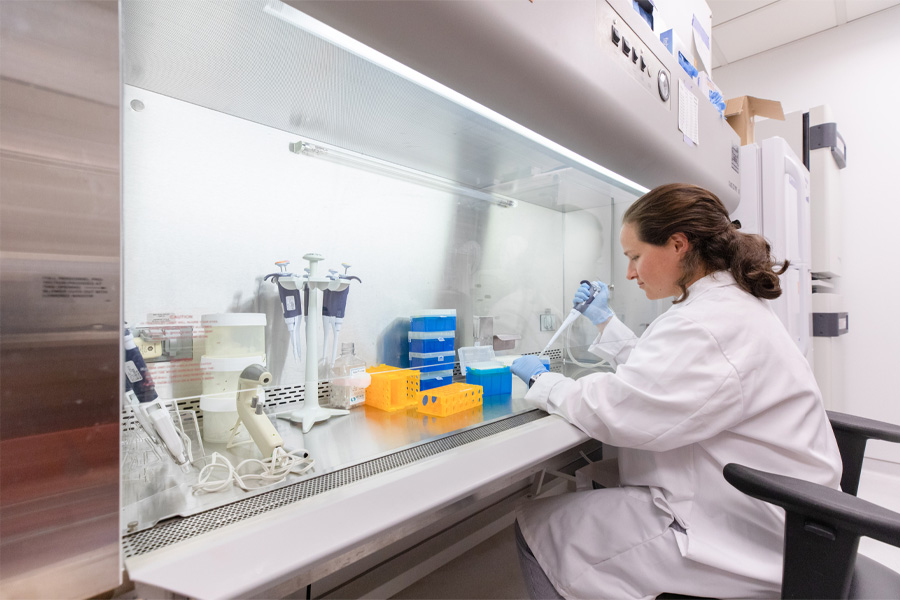 A female researcher works with lab equipment