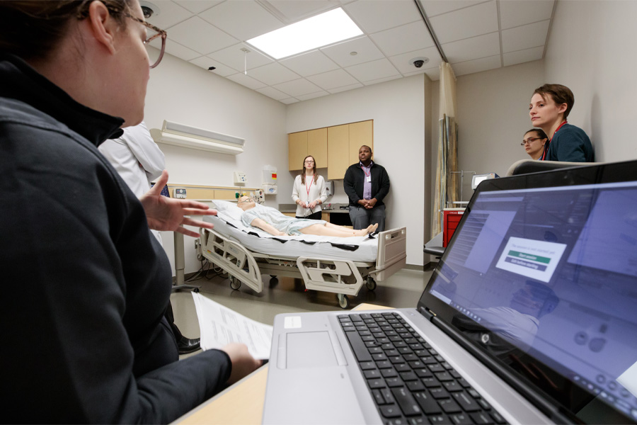 A student works on a laptop in a patient room