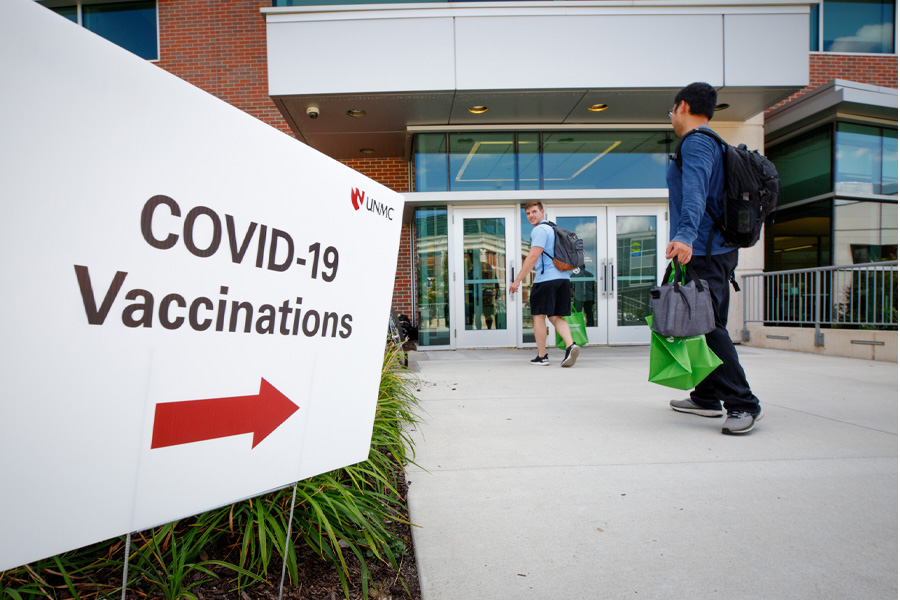A sign reading "COVID-19 Vaccinations" points to a nearby facility