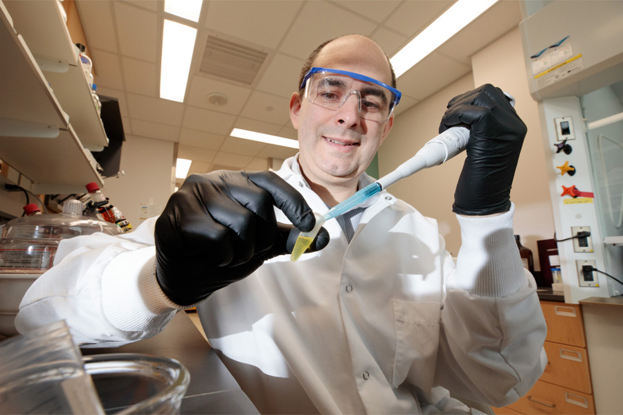 A researcher using a pipette and beaker.