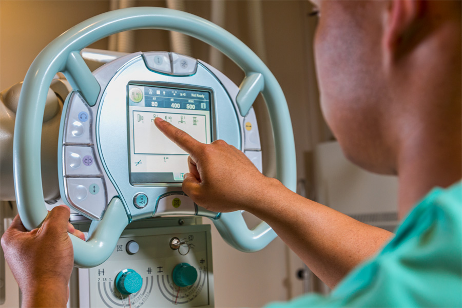 A health care worker interacts with a digital screen