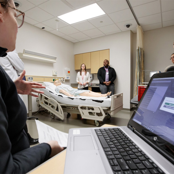 A student works with a computer in a patient room