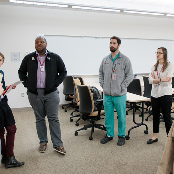 A group of people converse in a classroom