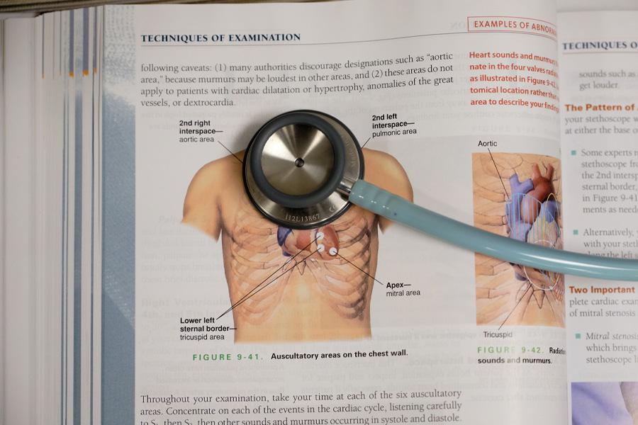 A stethoscope lying on a medical textbook