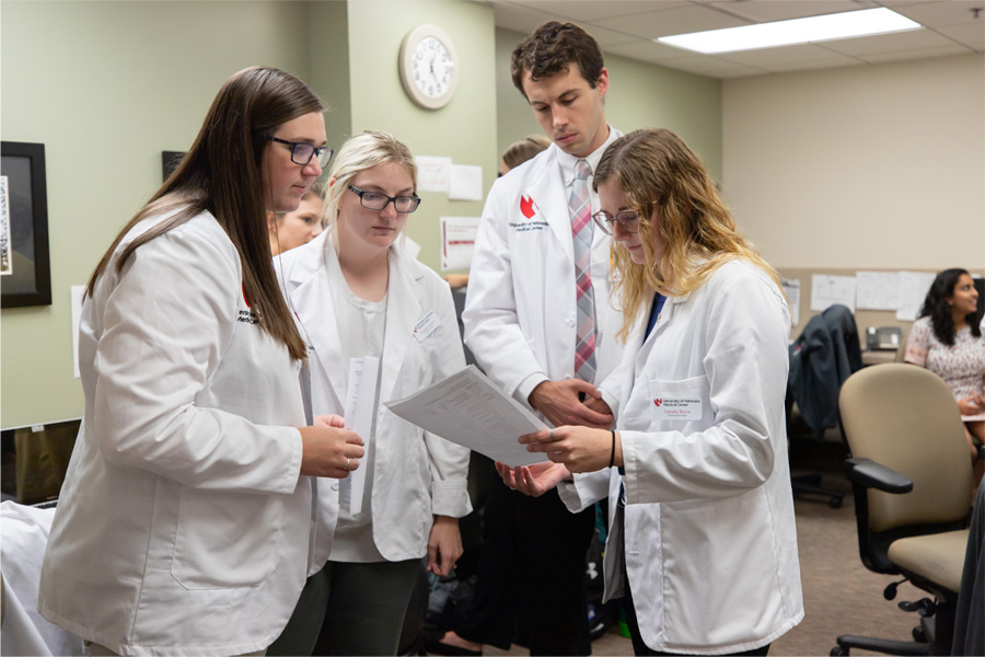 A group of health care providers in white coats consult