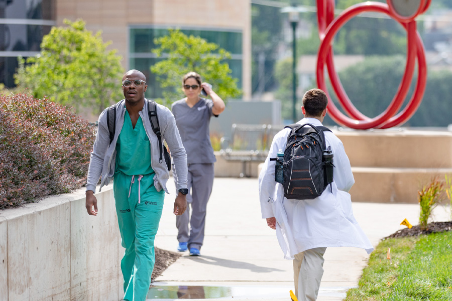 Health care providers walk on UNMC's Omaha campus