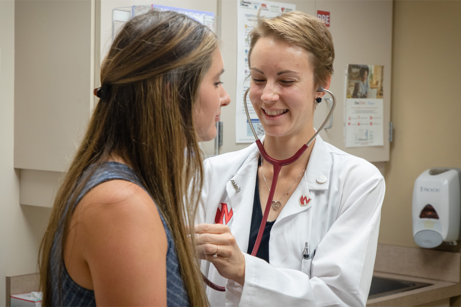 A female health care professional works with a female patient