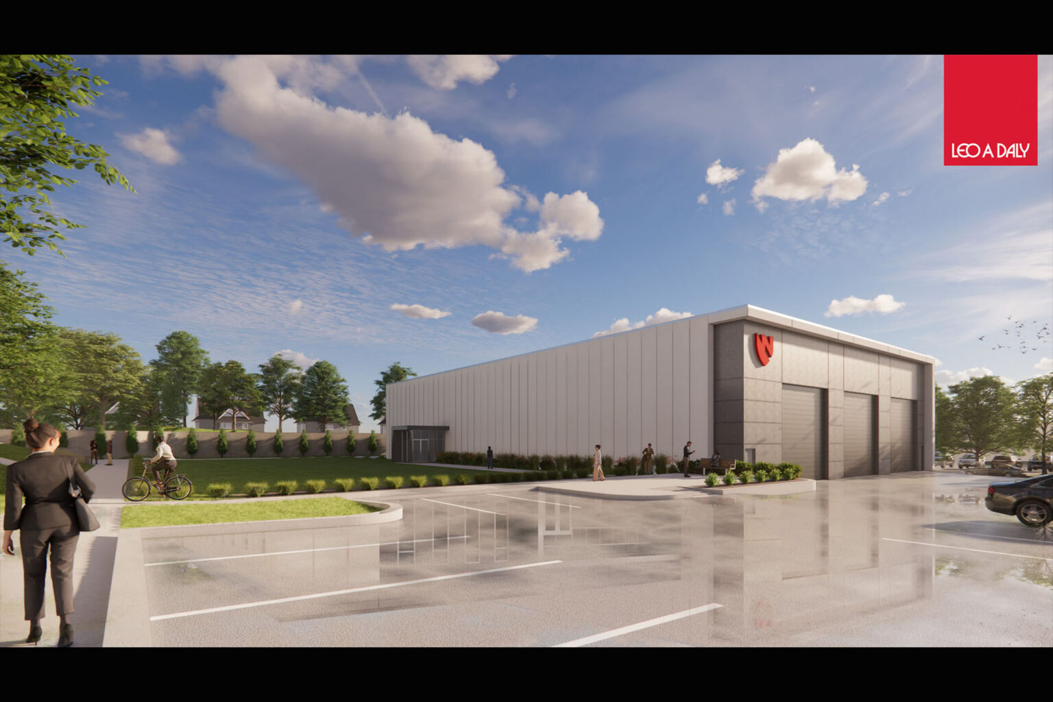 Modern industrial facility with landscaped grounds, people walking, and a large warehouse-style building under a partly cloudy sky.