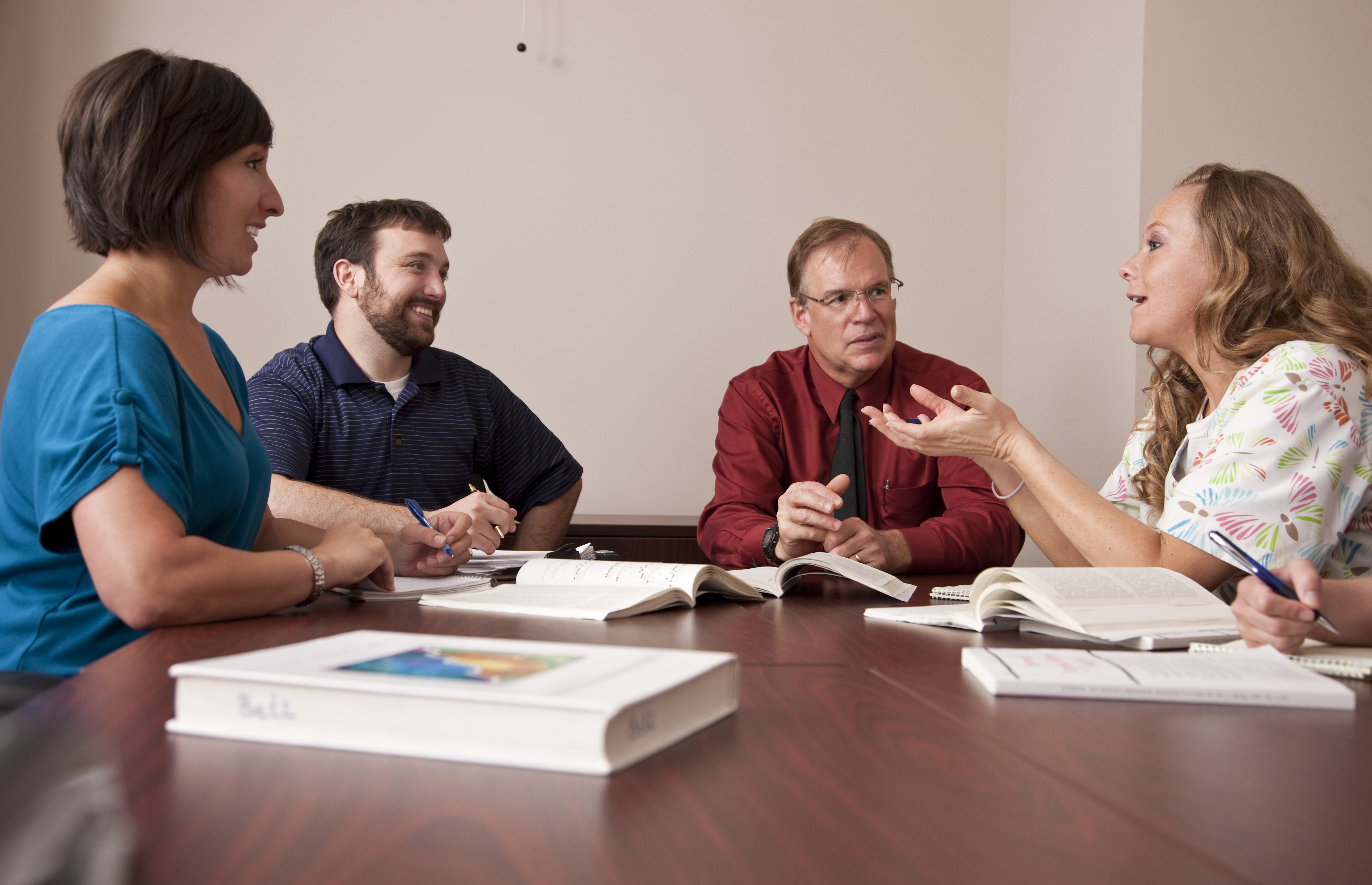 a group of people in a classroom setting smiling and studying