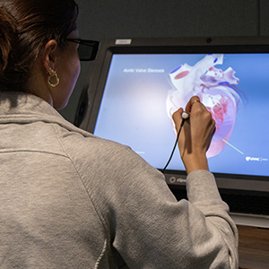 nurse dissecting virtual heart on 3D workbench