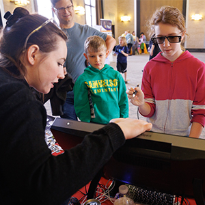 iEXCEL staff assisting young children with the 3D workbench