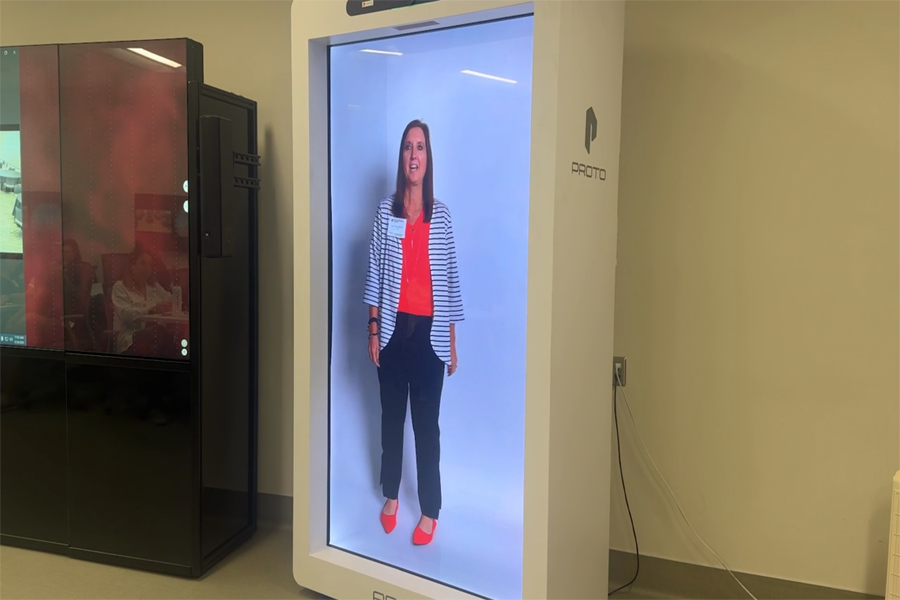 A life-sized, live video of a person giving an interview from a holo box