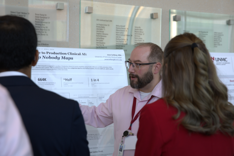 man presenting a research poster to audience 